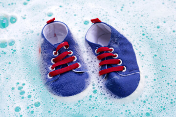 Soak baby shoes in baby laundry detergent water dissolution before washing. Laundry concept, Top...