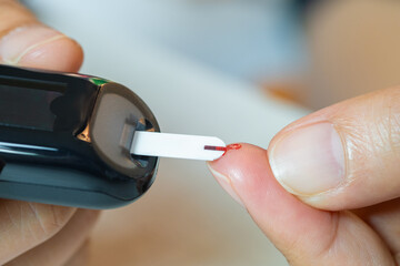 hand of people check diabetes and high blood glucose monitor with digital pressure gauge. Healthcare and Medical concept