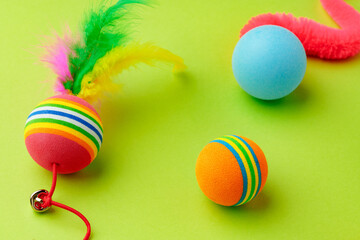 Colorful pet toys balls on green background