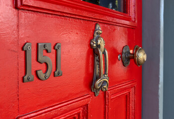 Red door with brass hinges and locks. Brass doorknocker. Ponsonby Road. New Zealand.
