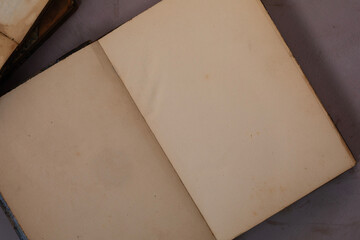 Close top down view of an open blank yellow pages of an antique vintage book on light purple...