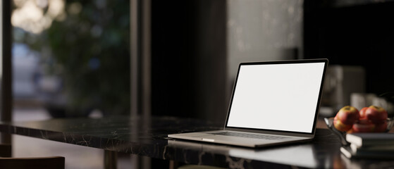 A white-screen laptop computer mockup on a black marble tabletop in a modern black dining room.