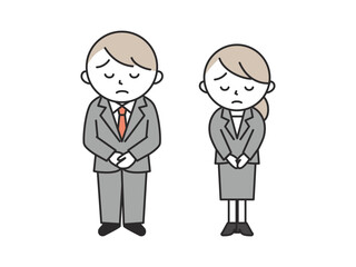 困った表情でお辞儀をしてお詫びするスーツ姿の若い男性と女性