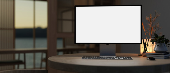 A white-screen PC computer and accessories on a table in a modern dark room.