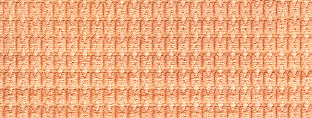 Color of the year 2024 peach fuzz. Light orange background from fabric closeup. Texture of coral textile backdrop