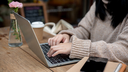 Cropped shot of a woman working remotely at a cafe in the city, working on her laptop computer.