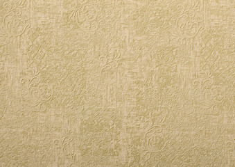 Background of beige wallpaper or plaster wall with vintage swirl pattern.