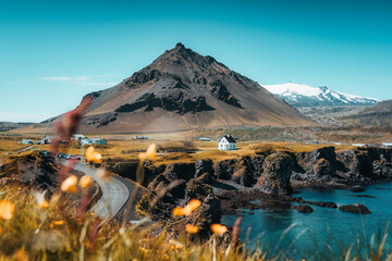 Arnarstapi fishing village with nordic house and stapafell volcano mountain by basalt rocks...