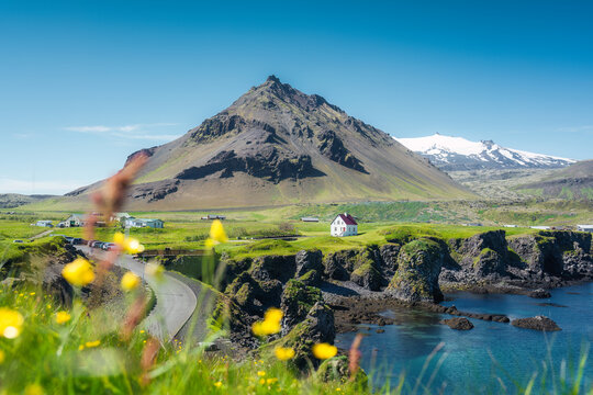Arnarstapi fishing village with nordic house and stapafell volcano mountain by basalt rocks formation in Snaefellsnes peninsula at Iceland