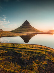 Kirkjufell volcanic mountain reflect on lake in the morning at Iceland