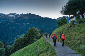 Fototapeta na wymiar Group of backpacker hiking on trail in Swiss Alps valley on summit