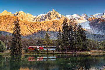 Lac des Gaillands with train passing and Mont Blanc massif reflection in the sunset at Chamonix, France