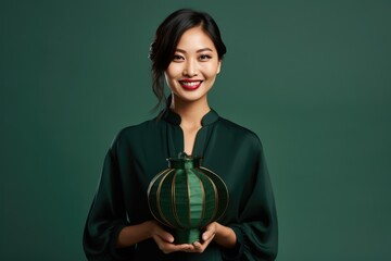 A woman holding a unique green ceramic vase