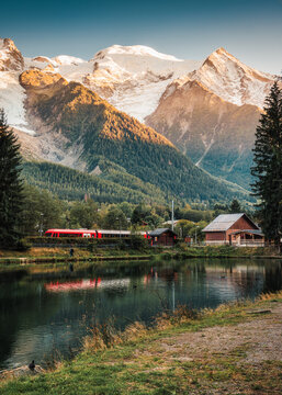 Lac des Gaillands with Mont Blanc massif and train at station in the sunset at Chamonix
