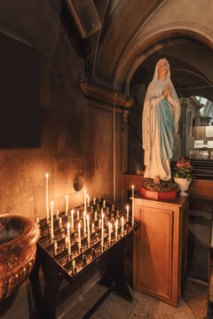 Statue mother virgin mary praying and candlelight altar in christian chruch