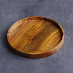 photo of a handmade wooden plate, with a beautiful texture. shiny brown. recycle. suitable for cafe...
