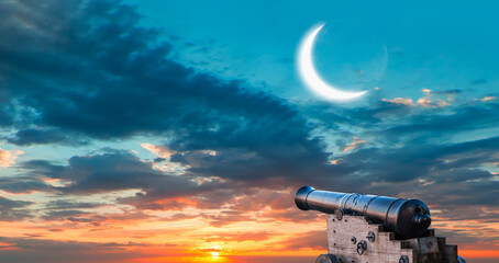 Ramadan Concept - Ramadan kareem cannon with crescent - Dusk sky with moon in the clouds at sunset