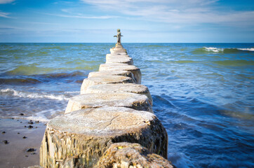 Groynes jut out into the Baltic Sea. Wooden trunks to protect the coast. Landscape