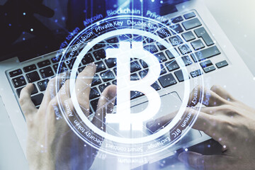 Creative Bitcoin concept with hands typing on laptop on background. Multiexposure