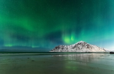 Northern lights aurora borealis taken during snow covered winter season on Lofoten islands in Norway