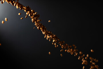 Coffee beans in motion on a black background.