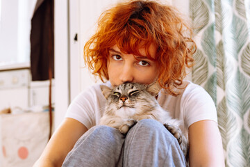 Portrait red-haired curly teenage girl with favorite fluffy domestic cat