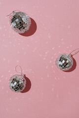 Shining disco balls with mirrored lights on pink background with blank copy space. Aesthetic holiday party event. Sparkling retro disco ball mockup template