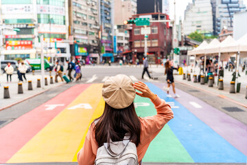 Naklejka premium Young female tourist with Rainbow Road crossing at Ximending landmark and popular attractions in Taipei, Taiwan
