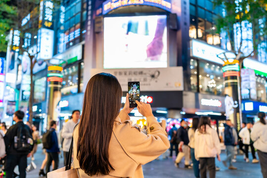 Young female tourist taking a photo of the Ximending shopping street landmark and popular attractions in Taipei, Taiwan