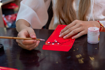 Selective focus of hand of Vietnamese scholar writes calligraphy at lunar new year. Calligraphy...