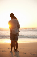 Man, woman and beach hug at sunset for summer travel or adventure, bonding or marriage. Happy...