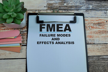 Concept of FMEA - Failure Modes and Effects Analysis write on paperwork isolated on wooden...