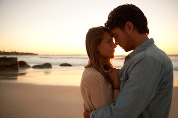 Couple, embrace and relax on beach at sunset for bonding marriage or vacation, weekend or peace....