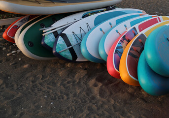 many, a lot SUP boards in the row for rent on sandy beach in Batumi, Georgia. Black sea. Relax on...