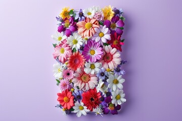 Colorful assorted flowers meticulously arranged to form a rectangular shape on a purple backdrop