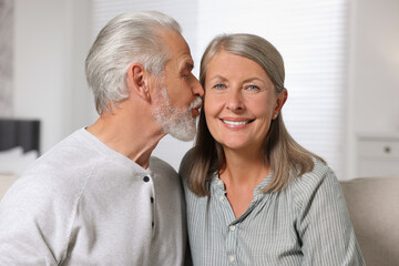 Senior man kissing his beloved woman indoors
