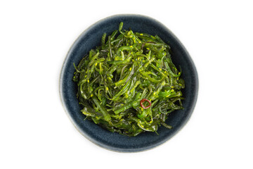 Chuka seaweed salad in blue ceramic bowl isolated on white. Top view