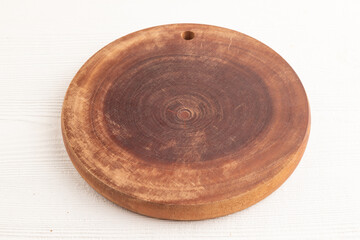 Empty round wooden cutting board on white wooden. Side view