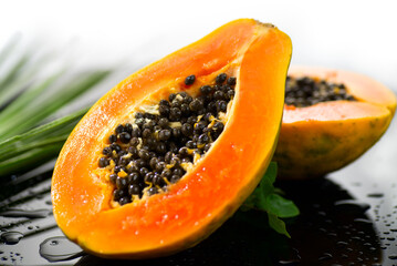 Papaya Exotic fruits close up. Papaya orange fresh fruits border design with tropical palm leaf. Halved fresh organic Papayas exotic fruits close up