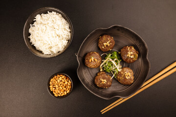 Tteokgalbi or Korean Grilled Short Rib Beef Patties Topping with Pine Nuts and Served with Rice .