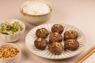 Tteokgalbi or Korean Grilled Short Rib Beef Patties Topping with Pine Nuts and Served with Rice .