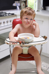 Eating, toddler and boy in chair for food, feeding or meal in house kitchen or home for breakfast....