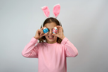 Funny happy child girl with easter eggs and bunny ears