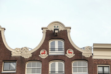 Fototapeta na wymiar Amsterdam Prinsengracht Canal House Facade Detail with Gable Stones Depicting Red Deer, Netherlands