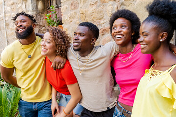 Young happy smiling multiracial group of people hugging together outdoors - Lifestyle concept with...