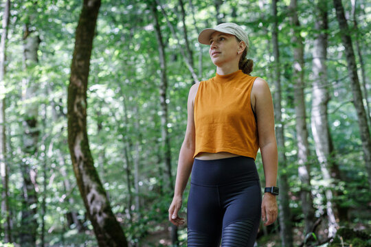 Fitness woman in sportswear walking through the woods