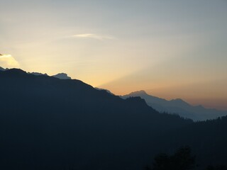 the sun is setting over a mountain range