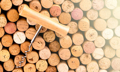 Corkscrew with a wooden handle against the background of wine bottle corks