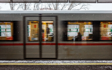 Hungarian Train Station in Snowy Winter Setting, with blurred train in movement