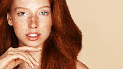 Beauty Freckles young girl portrait. Attractive model with beautiful natural long ginger red hair...